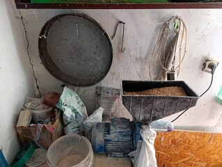 A kitchen with a bucket of food and a fan on the wall