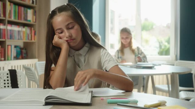 Sad bored girl Caucasian child student schoolgirl pupil learner tired upset daughter at desk sleepy exhausted teenager kid lesson class learning reading book education boring textbook studying library