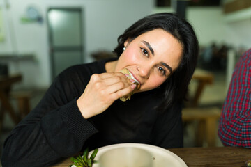 Happy customer eating a taco at a taco shop, enjoying authentic mexican cuisine