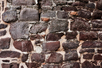 A wall made of stone with a rough texture. The wall is brown and white