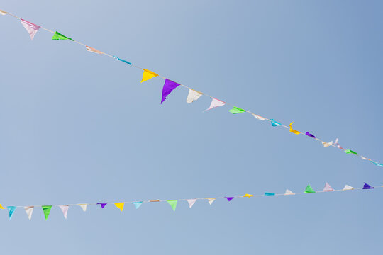 Colorful triangular pennant flags against clear blue sky