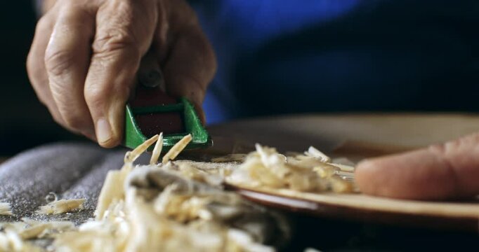 Super slow motion macro of experienced master luthiers hands carve violin with meticulous care at 1000 fps. Each precise cut highlights artistry and expertise behind creation.