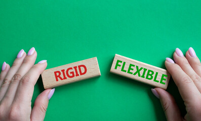 Rigid or Flexible symbol. Concept word Rigid or Flexible on wooden blocks. Businessman hand. Beautiful green background. Business and Rigid or Flexible concept. Copy space