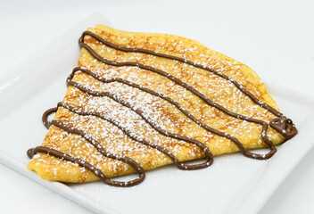 Panqueques con chocolate sobre un fondo blanco, primer plano