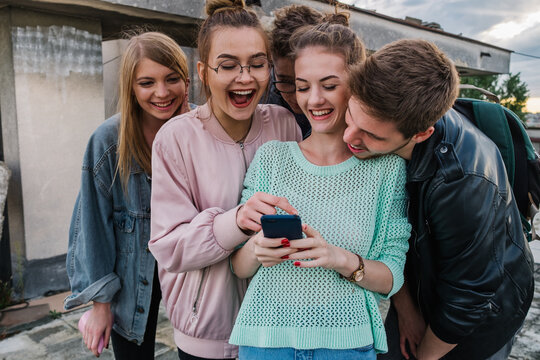 Friends looking at the funny photo on the mobile phone 
