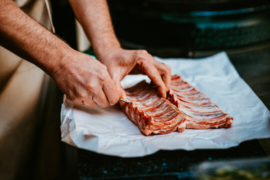chef prepares pork ribs for cooking with precision and care