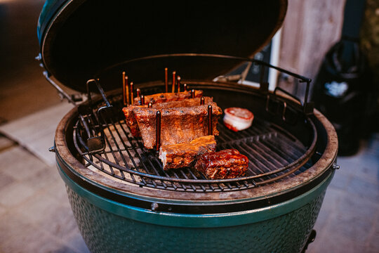 ribs intricately arranged on a green egg grill with open lid