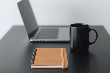 Fototapeta premium Minimalist workspace with an open notebook, laptop, and a mug on a clean desk, creating a modern and organised office environment with neutral tones and simple design