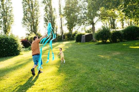 Father and son flying kite in park during daytime
