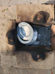 boiling milk inside muddy stove. Rural kitchen. Traditional stoves used by residents in rural India, pakistan, Bangladesh, nepal, afganistan, Sri Lanka and undeveloped countries. made of clay 