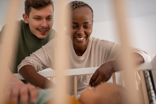 Parents watching baby in crib