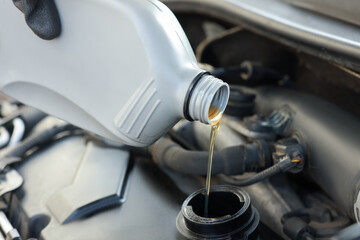 Pouring motor oil into car engine, closeup