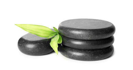 Spa stones and green leaves isolated on white