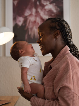 Mother talking to laughing newborn 