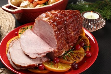 Tasty baked ham served on black wooden table, closeup