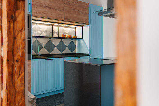 Modern kitchen with light blue cabinets and geometric tile backsplash