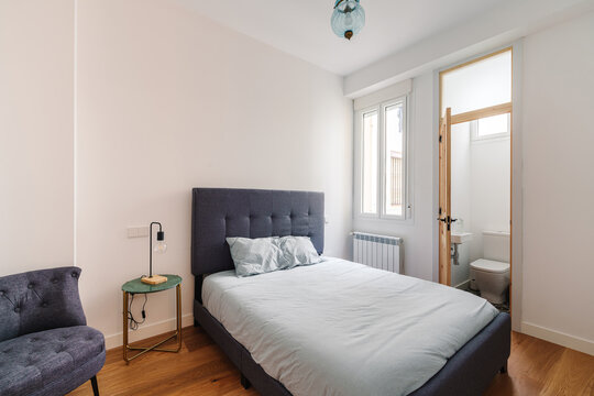 Minimalist bedroom with double bed and a small en-suite bathroom