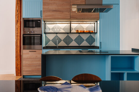Modern kitchen with a blue island and wooden cabinets