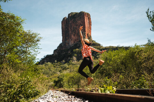 woman jumping with arms outstretched in bautiful landscape