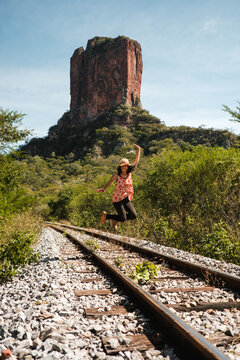 woman jumping with arms outstretched in bautiful landscape