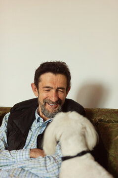 An older man is having fun with his best friend - maltese dog