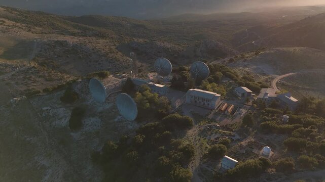 Satellite dishes on mountaintop at sunset