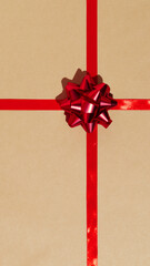 Red gift ribbon and bow on craft wrapping paper