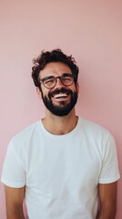 Obraz premium Smiling man poses confidently against a pink background wearing a simple white shirt