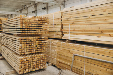 Stacks of timber planks forming geometric patterns in warehouse