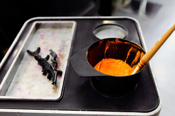 Hair coloring setup with orange dye and black hair clips