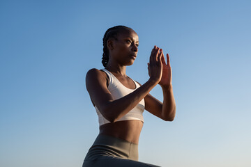 Girl exercising against blue sky