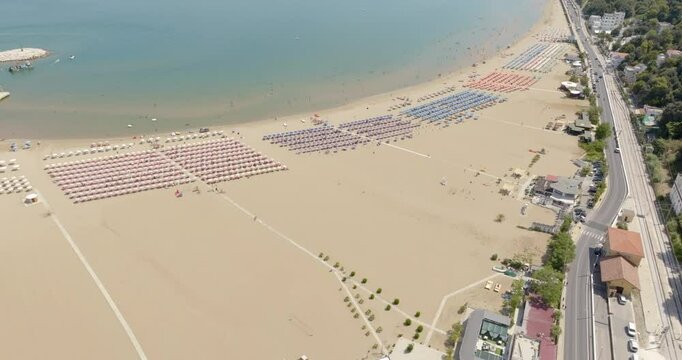 Aerial view of Levante beach in Rodi Garganico. It is a tourist destination in Gargano, in the province of Foggia, Puglia, Italy. There are many umbrellas, beach clubs and people on vacation.