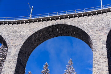 Fototapeta premium Scenic view of railway viaduct named Schmittentobel at Albula Valley in the Swiss Alps on a sunny autumn day. Photo taken November 22nd, 2024, Schmitten Albula, Switzerland.