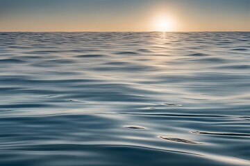 A close-up of the surface of seawater, with gentle ripples creating a dynamic texture. The water is clear, with soft reflections of sunlight shimmering across the surface.