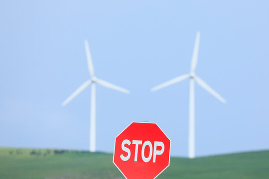 A road stop sign with two wind turbines in the background. Australia.