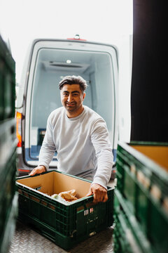 Delivery man holding groceries crate