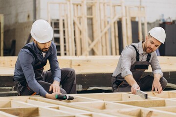 Construction workers building wooden frame for modular house