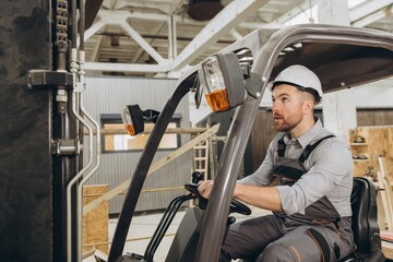 Builder driving forklift in modular building factory