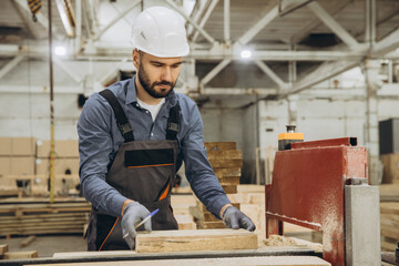 Carpenter measuring wooden plank in workshop for modular building