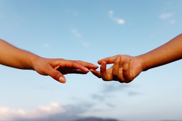 Crop female hands touching in sunset