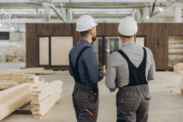 Engineers inspecting prefabricated modular building in factory
