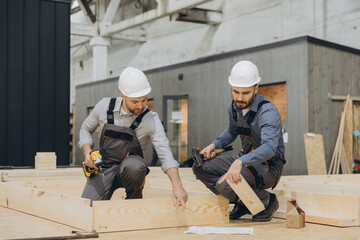 Construction workers building wooden frame for modular house