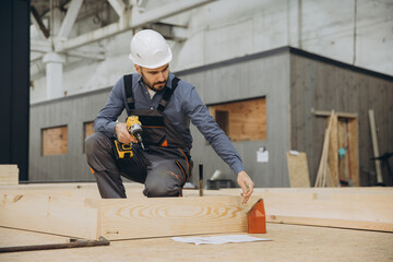 Carpenter building wooden frame for modular house in factory