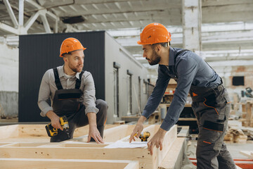 Builders working on wooden frame for modular building