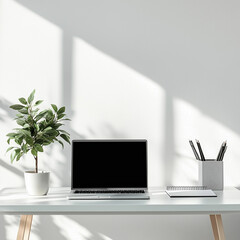 Fototapeta premium Minimalist desk setup featuring laptop, notepad, and decorative plant in bright workspace