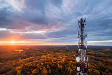 Communication tower above autumn forest blends technology with seasonal natural beauty