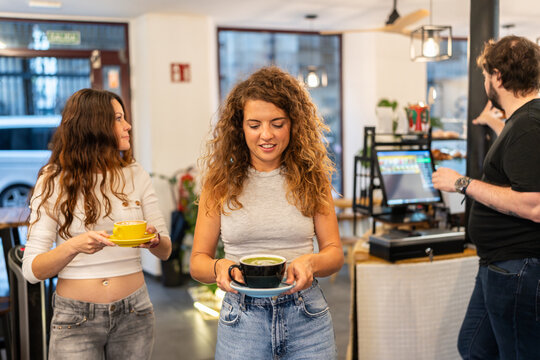 Young people holding coffee and matcha latte in coffee shop