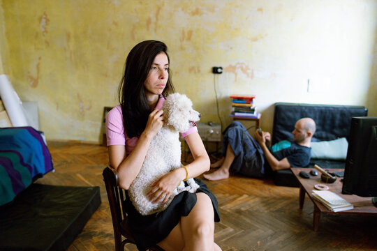 a woman sits in a room with a dog
