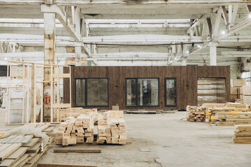 Workers building modular home in large warehouse