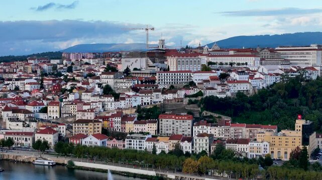 4K drone video footage of Coimbra city old town on the hill. Panoramic aerial cityscape of Coimbra university and Mondego River, Portugal